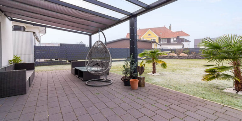 Überdachte Terrasse mit Blick in den Garten, ideal für entspannte Stunden.